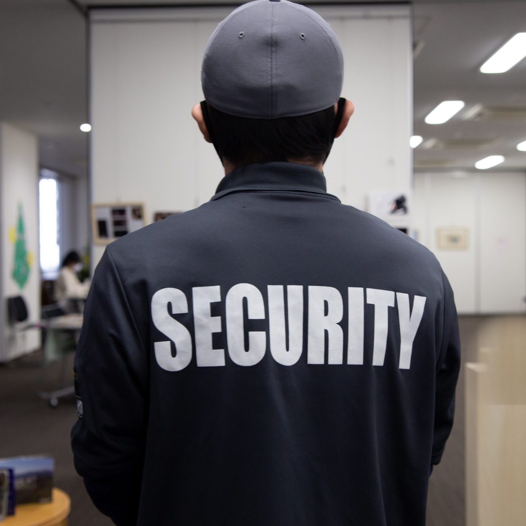 Rear view of a security guard, vest visible. 