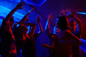 Joyful dancers with raised hands enjoying prom