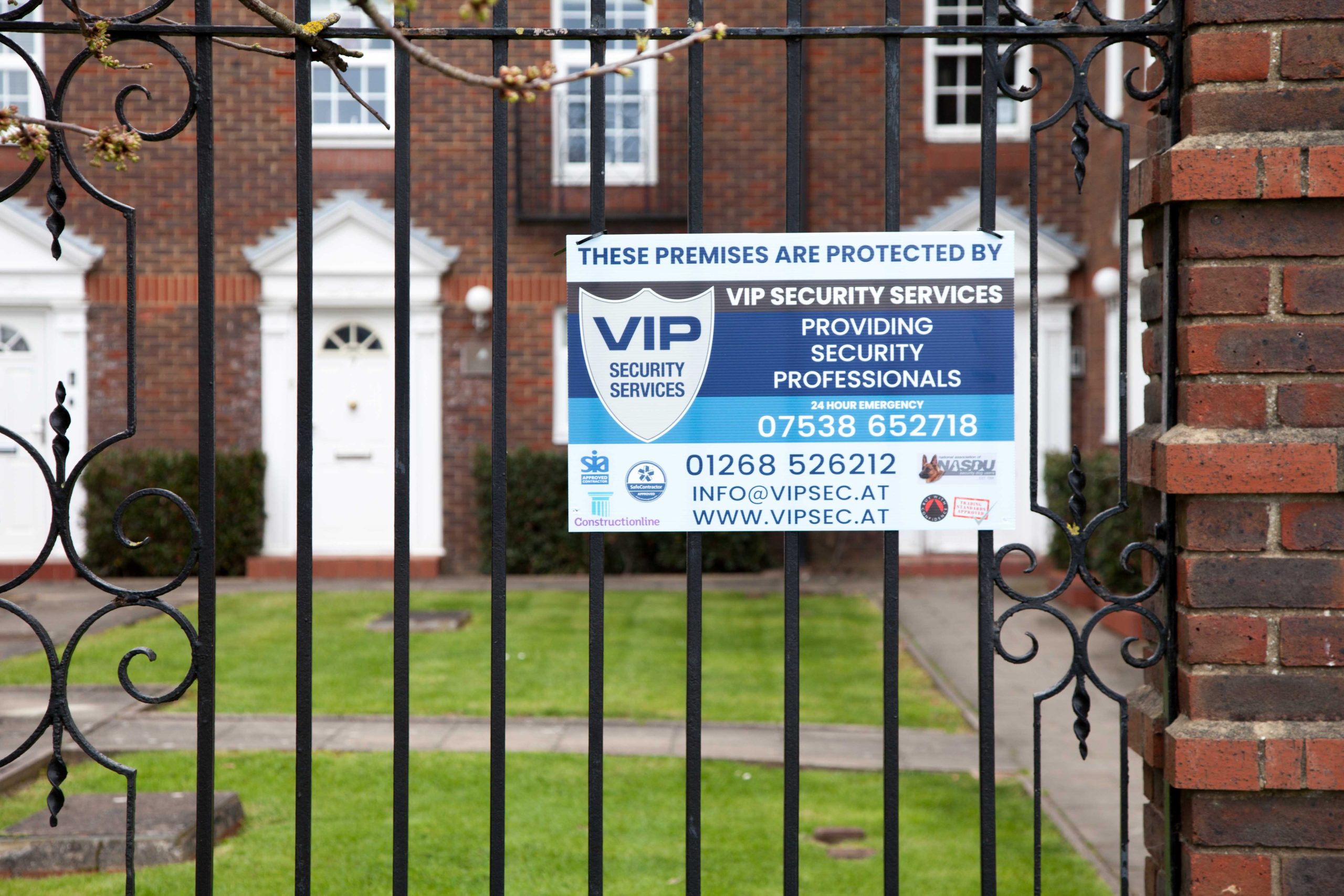 VIP Security Services sign, hanging on fence. 